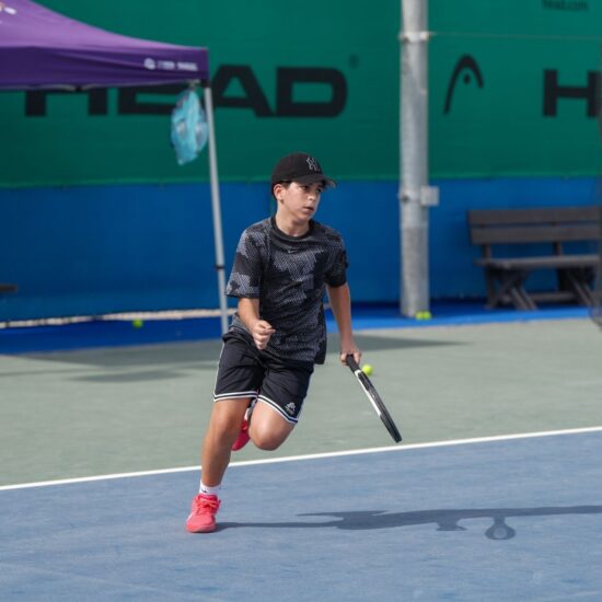 A boy learning tennis at a kid's tennis coaching in dubai sports city at ISD ProStyle Tennis