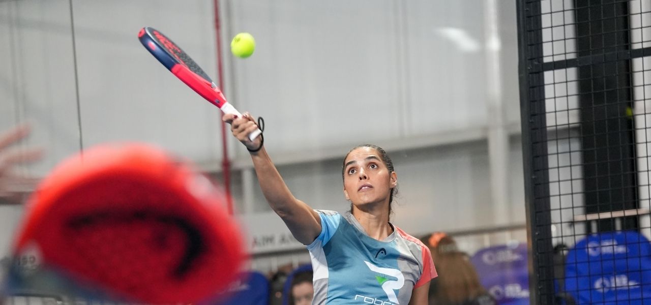 A lady playing padel in one of ISD Padel's indoor padel tennis courts in dubai sports city