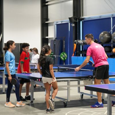 Table Tennis Coach Alexey Livenstov teaching young kids how to play table tennis at ISD Table Tennis in Dubai Sports City