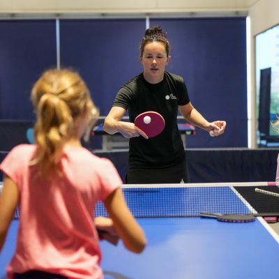 Table Tennis Coach Yulia Prokhorova teaching a young girl how to play table tennis at ISD Table Tennis in Dubai Sports City