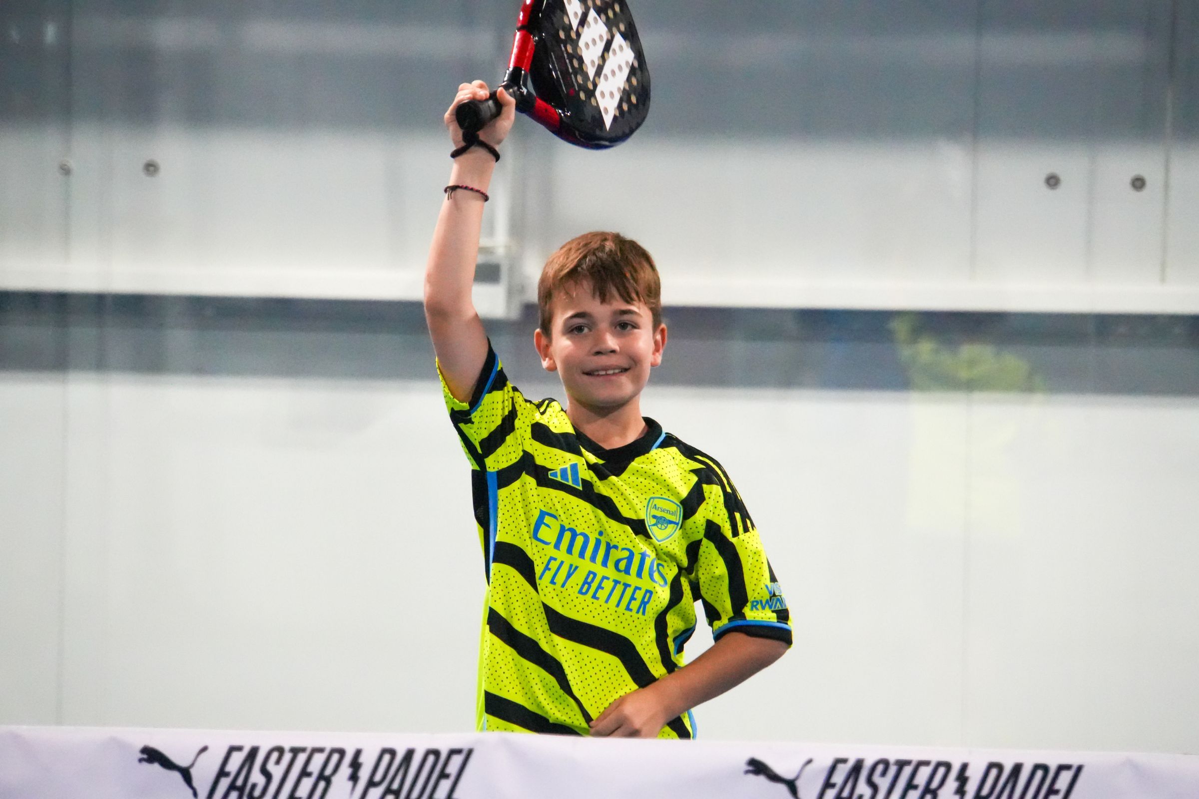 A boy smiling on a Padel court at ISD Padel in Dubai Sports City