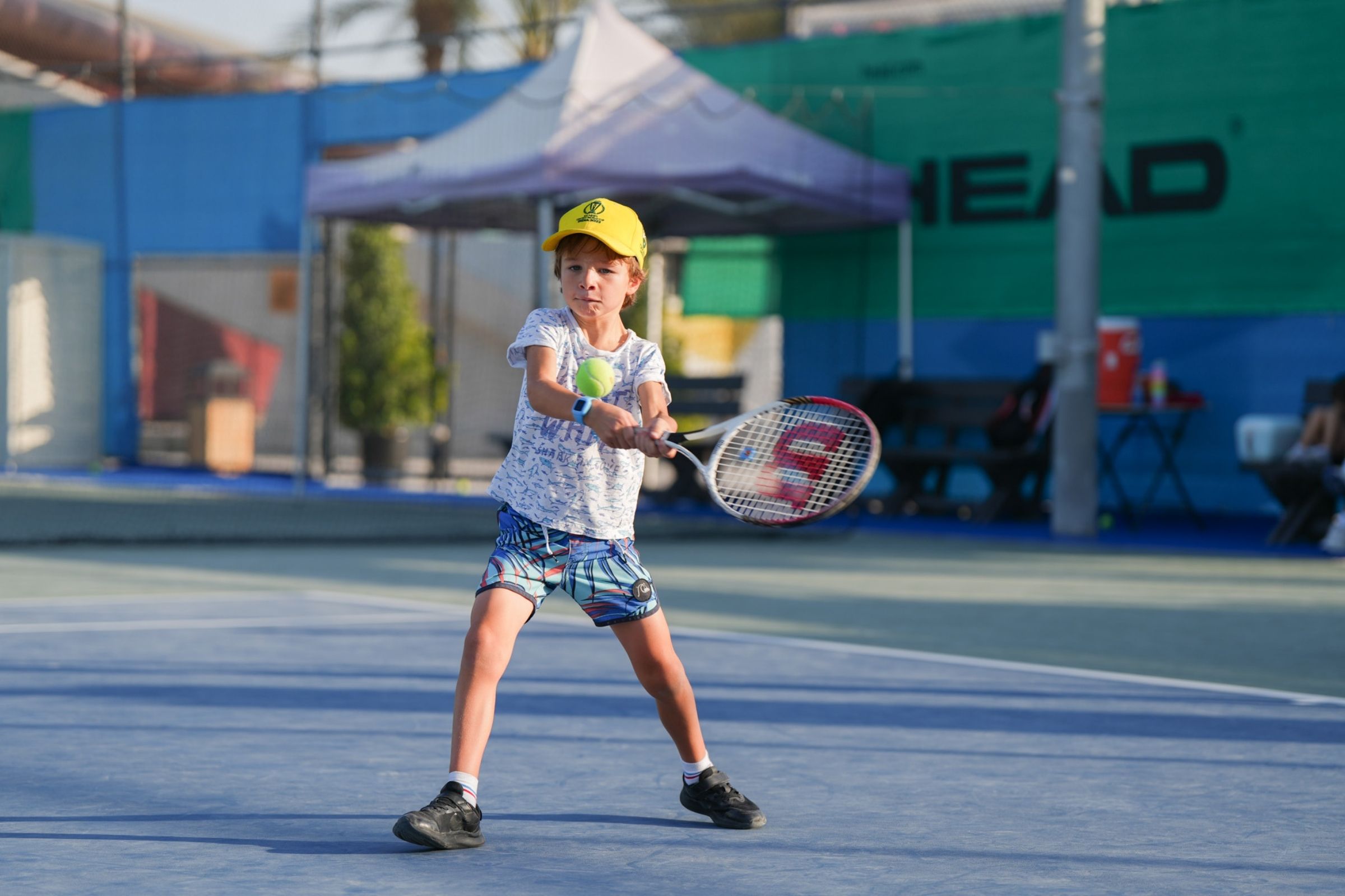 A child learning Tennis at ISD ProStyle Tennis Academy in Dubai Sports City