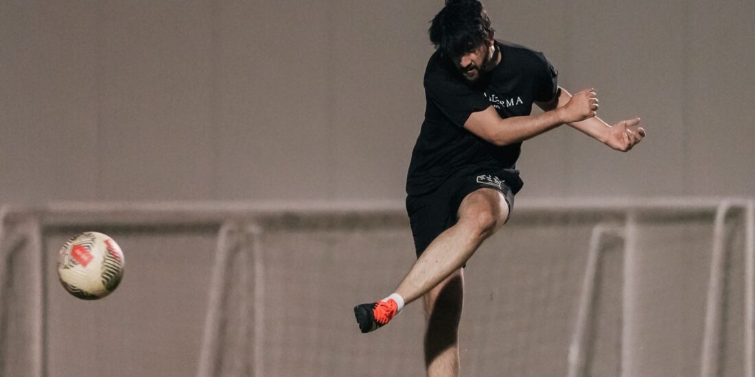 A corporate football player kicking a football during a match in the Dubai corporate football league (4)