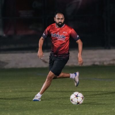 A corporate football player of Dubizzle's corporate football team kicking the football during a match in the Dubai Corporate Football League organized by ISD Football at ISD Dubai Sports City