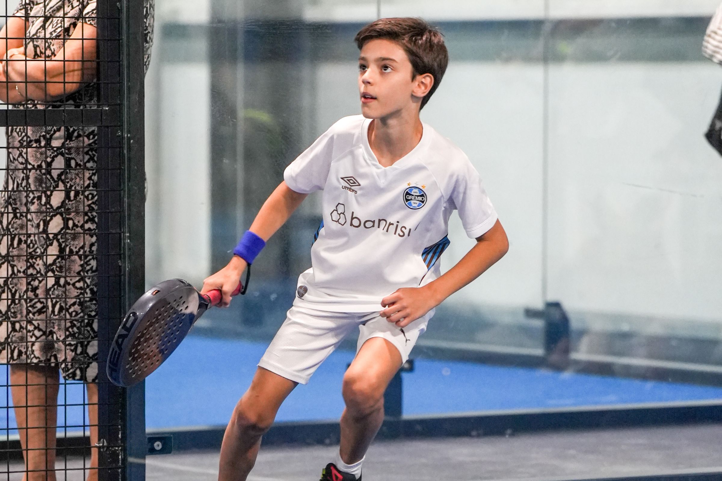 A kid running towards the ball during a Padel game at ISD Padel Academy in Dubai