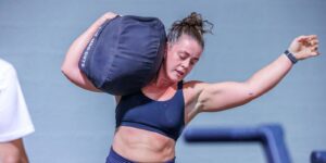 A woman carrying a heavy sand bag in the middle of an event in the precision pairs competition held at ISD Dubai Sports City