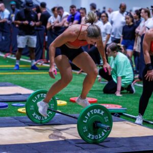 A woman in the middle of a weightlifting event in the precision pairs competition held at ISD Dubai Sports City