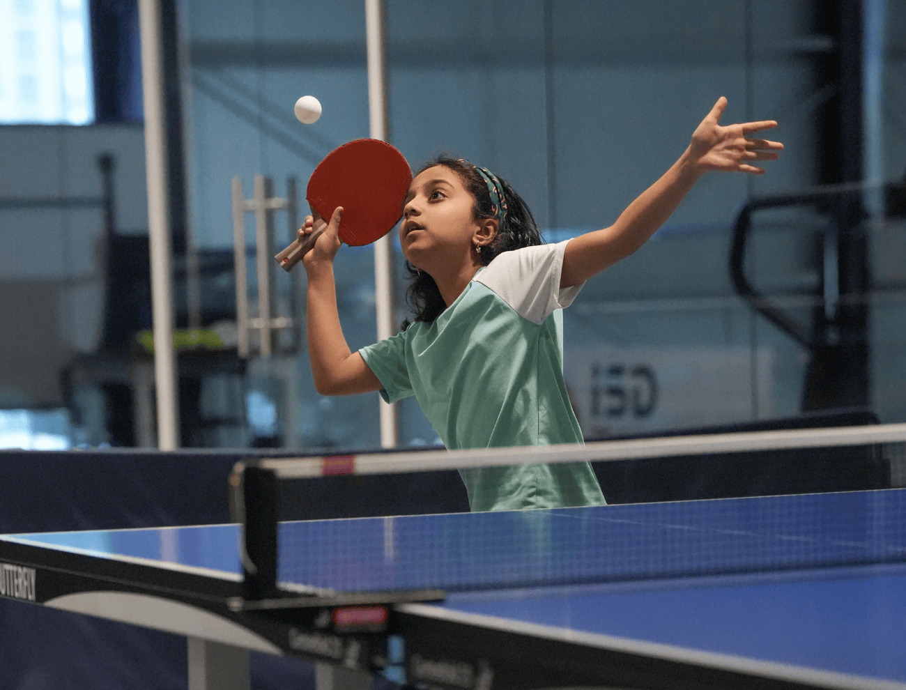 A young girl serving while playing Table Tennis at ISD Table Tennis Academy in Dubai Sports City