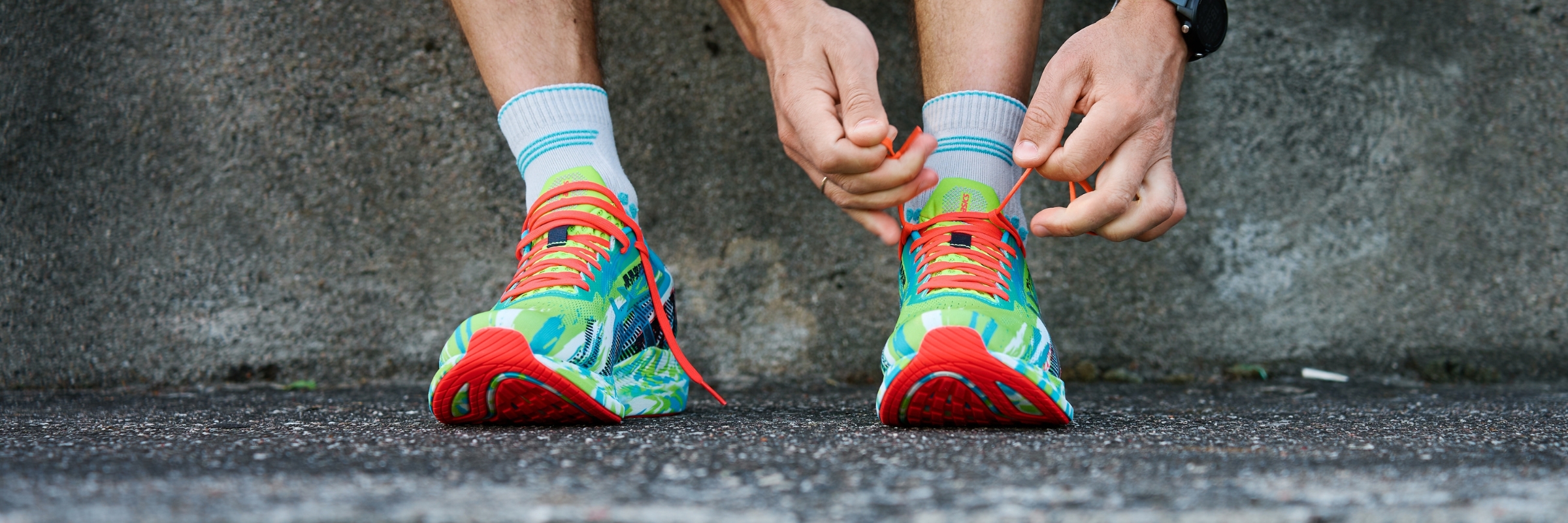 An Athletic man tying his running shoes before running