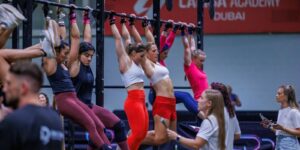 Female CrossFit athletes doing chin-ups during an event at Precision series held inside the indoor pitch at ISD Dubai Sports City