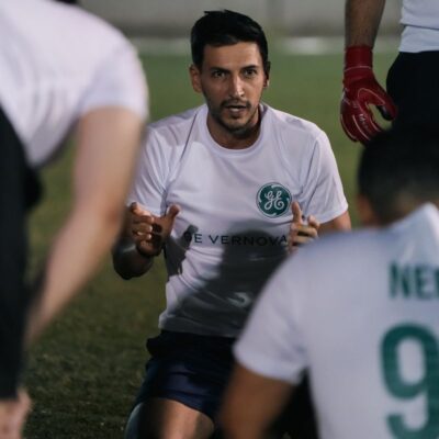 GE Vernova's corporate football team mentor dishing out strategy during the half-time of a match in the Dubai Corporate Football League organized by ISD Football at ISD Dubai Sports City