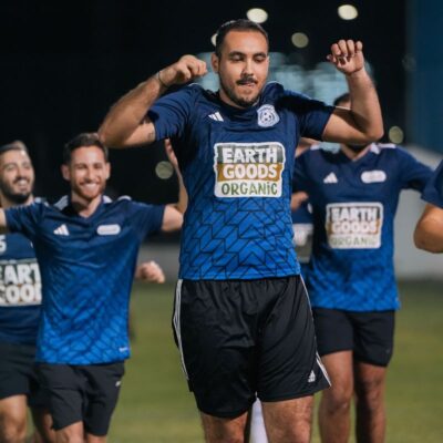 Players of Transmed's corporate football team celebrating a goal that they scored in a match in the Dubai Corporate Football League organized by ISD Football at ISD Dubai Sports City