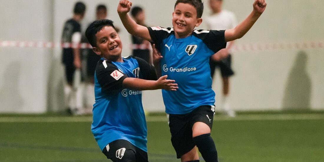 Two boys from LaLiga Academy Dubai's U10 Advanced Squad celebrating a goal during a match in DOFA League 2024 2025