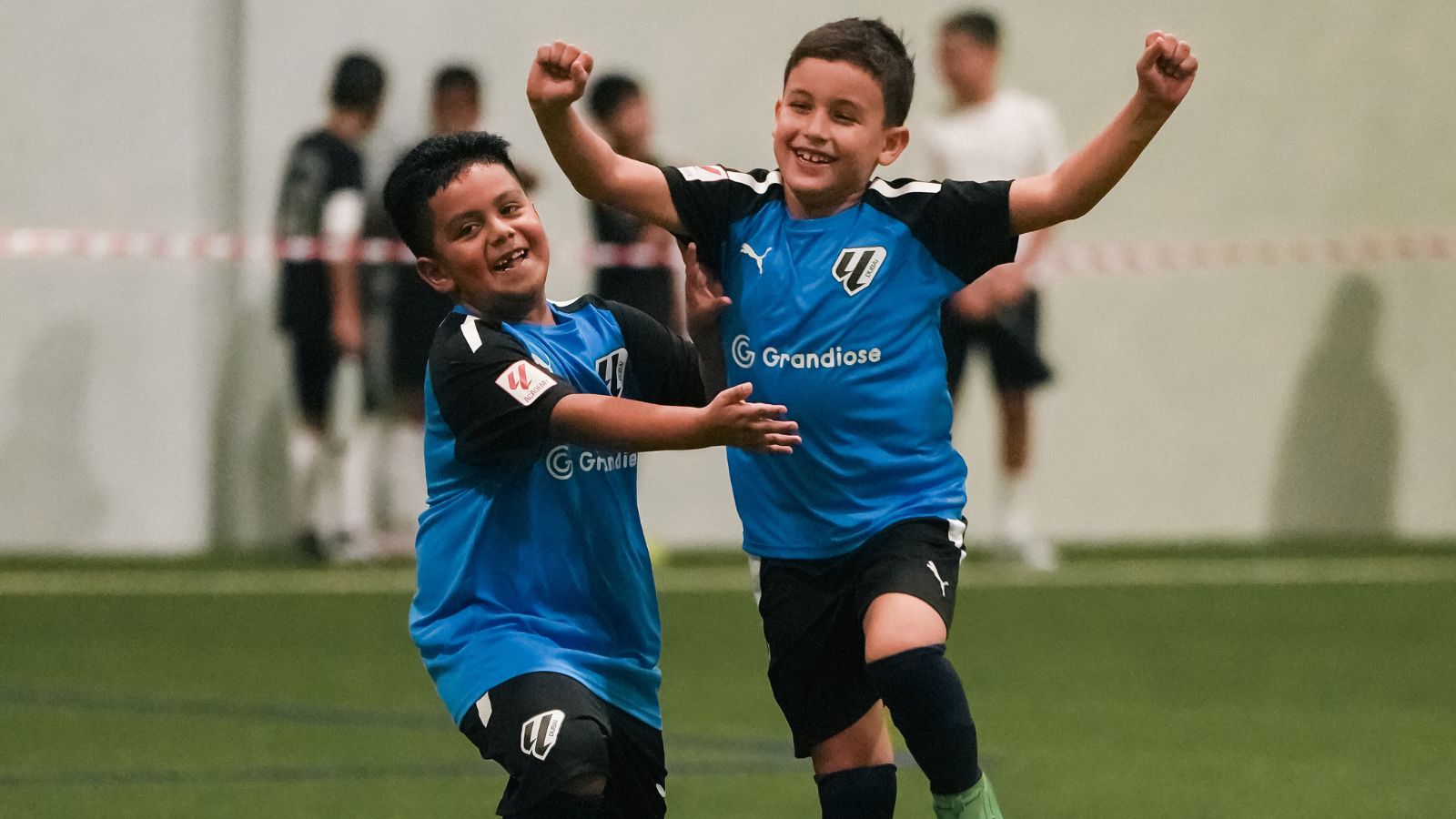 Two boys from LaLiga Academy Dubai's U10 Advanced Squad celebrating a goal during a match in DOFA League 2024 2025