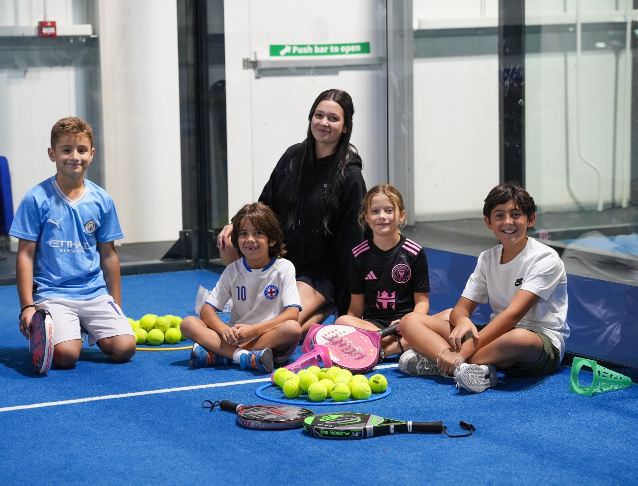 Padel coach Angelina N with kids during Racket Sports Camp at ISD Padel in Dubai Sports City