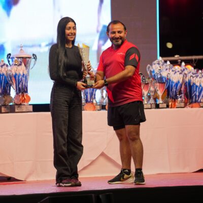 A coporate athlete accepting her prize on stage at the Dubai Corporate Games at ISD Dubai Sports City