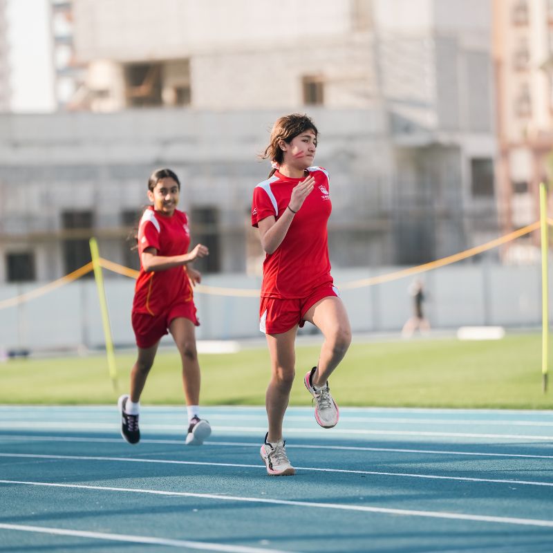 Two young girls running a race on the running track at ISD Dubai Sports City during their schools sports day (2)